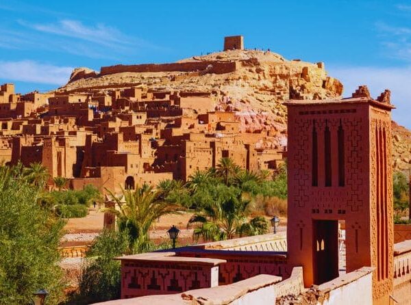 Traditional earthen buildings of Kasbah Ait Ben Haddou under a blue sky.